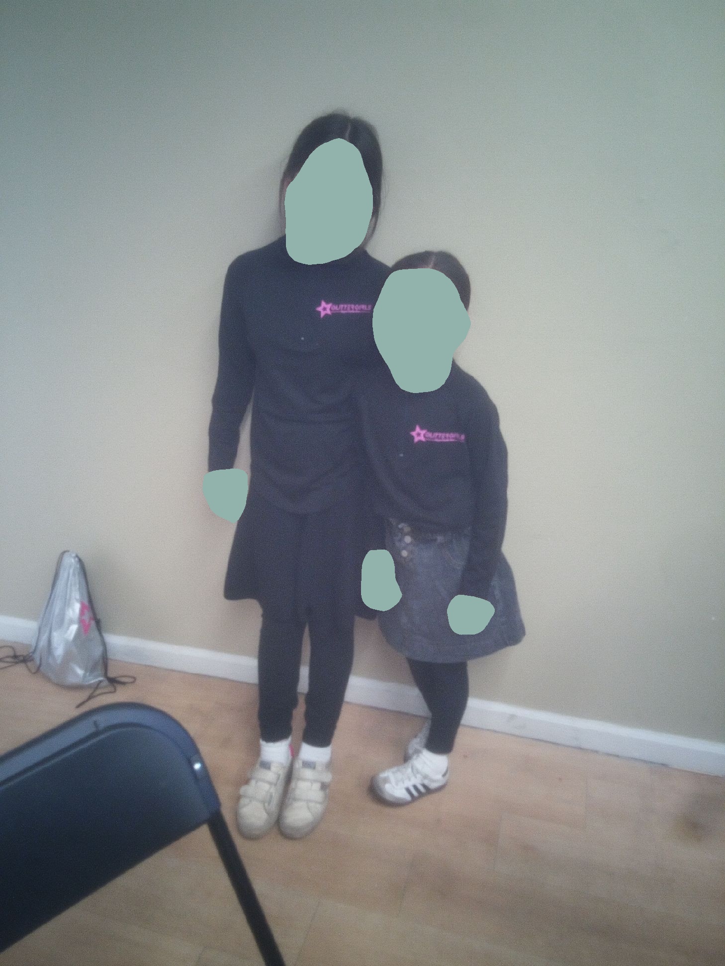 Two girls in matching Glitter Girls sweatshirts with a silver swag bag